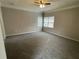 Spacious bedroom with neutral walls, a ceiling fan, gray carpeting, and windows that allow for plenty of natural light at 7123 Woodridge Ln, Union City, GA 30291