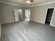 Spacious bedroom with neutral walls, a ceiling fan, gray carpeting, and multiple doors leading to other rooms at 7123 Woodridge Ln, Union City, GA 30291