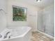 Bright bathroom with soaking tub, glass shower, and tiled floor at 2035 Stonebrook Dr, Austell, GA 30106