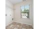 Functional laundry room with tile flooring, a window for natural light, and shelving for storage at 2035 Stonebrook Dr, Austell, GA 30106
