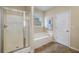 Bathroom featuring a tub with window, a shower with glass doors and ceramic tile floors at 3610 Chestnut Meadows Dr, Douglasville, GA 30135