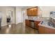 Well-lit kitchen featuring wood cabinets and stainless steel dishwasher overlooking the dining room at 3610 Chestnut Meadows Dr, Douglasville, GA 30135