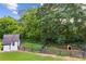 Well-maintained backyard featuring a shed, a small farm animal stall and trees at 4935 Stablegate Ct, Cumming, GA 30028