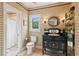 Charming bathroom featuring vintage-style vanity and patterned wallpaper at 4935 Stablegate Ct, Cumming, GA 30028