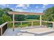 Deck overlooking a grassy pasture with trees along the fence line and a blue sky overhead at 4935 Stablegate Ct, Cumming, GA 30028