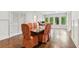 Elegant dining room with large windows, hardwood floors, custom lighting and wainscoting at 4935 Stablegate Ct, Cumming, GA 30028