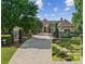 Grand estate with gated entrance, mature trees, and long driveway leading to the main house at 4935 Stablegate Ct, Cumming, GA 30028