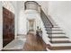 Elegant foyer with hardwood floors, staircase with iron railings, and arched doorway at 4935 Stablegate Ct, Cumming, GA 30028
