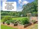 A beautiful raised garden with various vegetables, trees, and a cloudy sky at 4935 Stablegate Ct, Cumming, GA 30028