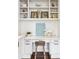 Close up of built-in desk with a wooden stool, white cabinets, and a shelf at 4935 Stablegate Ct, Cumming, GA 30028