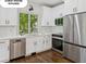 This modern kitchen boasts stainless steel appliances, white cabinetry, and an undermount sink at 4935 Stablegate Ct, Cumming, GA 30028