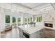 Open kitchen with large island, stone fireplace, and views of wooded land beyond large windows at 4935 Stablegate Ct, Cumming, GA 30028