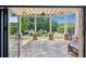 Covered stone patio overlooking the landscaped backyard, with views of the playhouse and garden at 4935 Stablegate Ct, Cumming, GA 30028