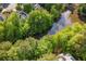 Aerial view of home near a lake surrounded by mature trees at 920 Waters Reach Ct, Alpharetta, GA 30022