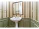 Charming powder room with pedestal sink, decorative mirror, elegant wallpaper, and wainscoting detail at 920 Waters Reach Ct, Alpharetta, GA 30022