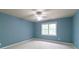 Serene blue bedroom with a ceiling fan and large window offering ample natural light and inviting ambiance at 920 Waters Reach Ct, Alpharetta, GA 30022
