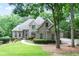 Beautiful brick home featuring a well-manicured lawn and mature trees offering a serene, picturesque setting at 920 Waters Reach Ct, Alpharetta, GA 30022