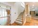 A staircase with carpet runners and white railing ascends to the upper level, with a dining room viewable at 920 Waters Reach Ct, Alpharetta, GA 30022