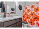 Stylish bathroom with granite vanity, decorative mirror, and vibrant floral shower curtain at 108 Fountain Oak, Villa Rica, GA 30180