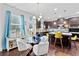Dining area with a glass table, white chairs, and views of kitchen with stainless appliances and granite counters at 108 Fountain Oak, Villa Rica, GA 30180