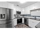 The renovated kitchen offers stainless steel appliances and white cabinets with stylish subway tile backsplash at 108 Fountain Oak, Villa Rica, GA 30180