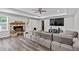 Spacious living room featuring a brick fireplace, a large sectional, and a modern ceiling fan at 108 Fountain Oak, Villa Rica, GA 30180