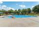 A large outdoor swimming pool with lounge chairs and umbrellas on a sunny day in a residential community at 1564 Brunswick St, Douglasville, GA 30135