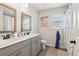 Well-lit bathroom featuring double sinks, wood-framed mirrors, and a shower with patterned curtain at 1564 Brunswick St, Lithia Springs, GA 30122