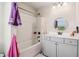 Bathroom with shower and bathtub combination and vanity with round mirror at 1564 Brunswick St, Lithia Springs, GA 30122