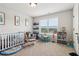 Bright bedroom with a crib, rug, play table and shelves with books near the window at 1564 Brunswick St, Lithia Springs, GA 30122
