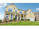 Charming two-story yellow home with a welcoming front porch and well-manicured lawn at 1564 Brunswick St, Lithia Springs, GA 30122