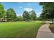 Community green space featuring a walkway, lush green lawn and mature trees, offering a serene atmosphere at 1564 Brunswick St, Lithia Springs, GA 30122