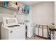 Bright laundry room with white washer and dryer and wire shelving above at 1564 Brunswick St, Lithia Springs, GA 30122