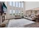 Open-concept living room featuring a stone fireplace, high ceilings, large windows, and hardwood floors at 1564 Brunswick St, Lithia Springs, GA 30122