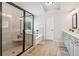Luxurious main bathroom featuring a glass-enclosed shower, soaking tub, and dual vanities at 1564 Brunswick St, Lithia Springs, GA 30122