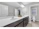 Bathroom with double vanity, large mirror, and ample lighting, complemented by neutral wall and floor tiles at 1840 Tululah Trl, Smyrna, GA 30082