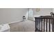 Clean bedroom with a crib, dresser, gray walls, neutral carpet, and a window for natural light at 1840 Tululah Trl, Smyrna, GA 30082
