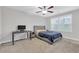 Simple bedroom with a gray upholstered bed, desk, ceiling fan, and natural light from the windows at 1840 Tululah Trl, Smyrna, GA 30082