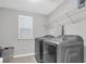 Functional laundry room with modern washer and dryer and convenient shelving at 1840 Tululah Trl, Smyrna, GA 30082