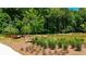 A scenic community area with walking paths, lush greenery, and an artistic insect sculpture near the pond at 344 Olmstead Way # 32, Alpharetta, GA 30022