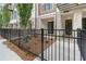 Charming exterior view of a townhouse with brick facade, black wrought iron fence, and landscaped front yard at 344 Olmstead Way # 32, Alpharetta, GA 30022