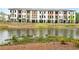 Townhome community featuring a pond, lush landscaping, and modern facades at 344 Olmstead Way # 32, Alpharetta, GA 30022