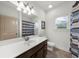 Bathroom featuring a single sink vanity, window, shower, and neutral accents at 4425 Martel Dr, Cumming, GA 30040