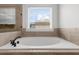 White bathtub offers a relaxing soak with natural light from a window at 4425 Martel Dr, Cumming, GA 30040