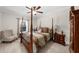 Cozy primary bedroom with a four-poster bed, accent chair, and ample natural light at 4425 Martel Dr, Cumming, GA 30040
