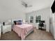 Neutral bedroom with desk, ceiling fan, two windows providing natural light, and side table at 4425 Martel Dr, Cumming, GA 30040