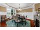Elegant dining room with wainscoting, modern chandelier, and seating for six at 4425 Martel Dr, Cumming, GA 30040