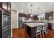 Elegant kitchen boasts stainless steel appliances, granite counters, and dark cabinets for a modern touch at 4425 Martel Dr, Cumming, GA 30040