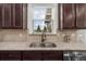 Granite countertop detail showcases a stainless steel sink, dark cabinetry, and neutral backsplash tiles at 4425 Martel Dr, Cumming, GA 30040