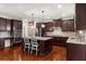 Spacious kitchen featuring dark wood cabinetry, granite countertops, and a functional center island with seating at 4425 Martel Dr, Cumming, GA 30040